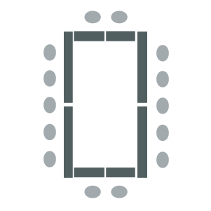 Room set up with table arranged in a large square with chairs around outside.