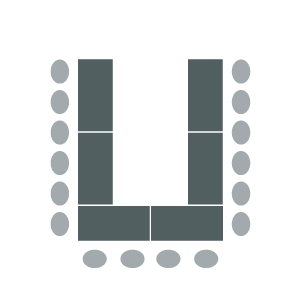 Room set up with tables arranged in "U" shape with chairs around outside.