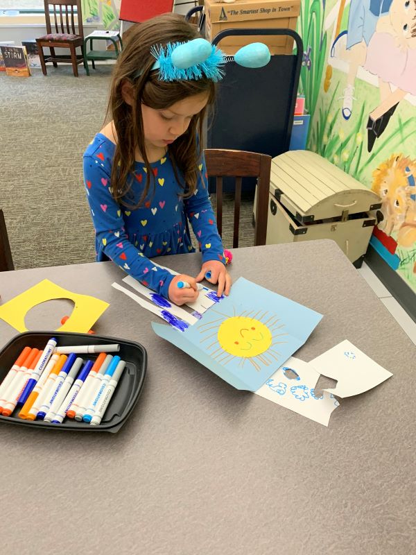 Girl at a table doing a craft project