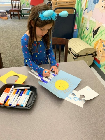 Girl at a table doing a craft project