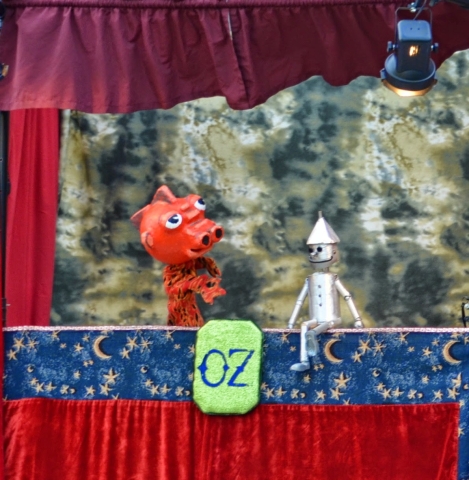 Puppet theatre with a red dinosaur and a tin man with OZ written beneath