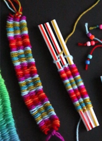 Three drinking straws with red and green thread weaving.