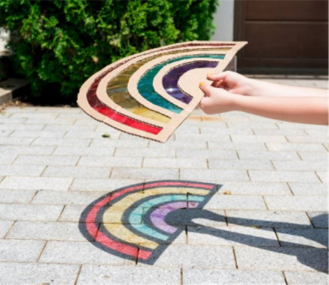 A light shining through a rainbow and projecting on the ground