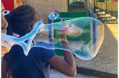 Kids blowing bubbles through homemade bubble wands
