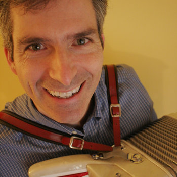 man smiling holding an accordian